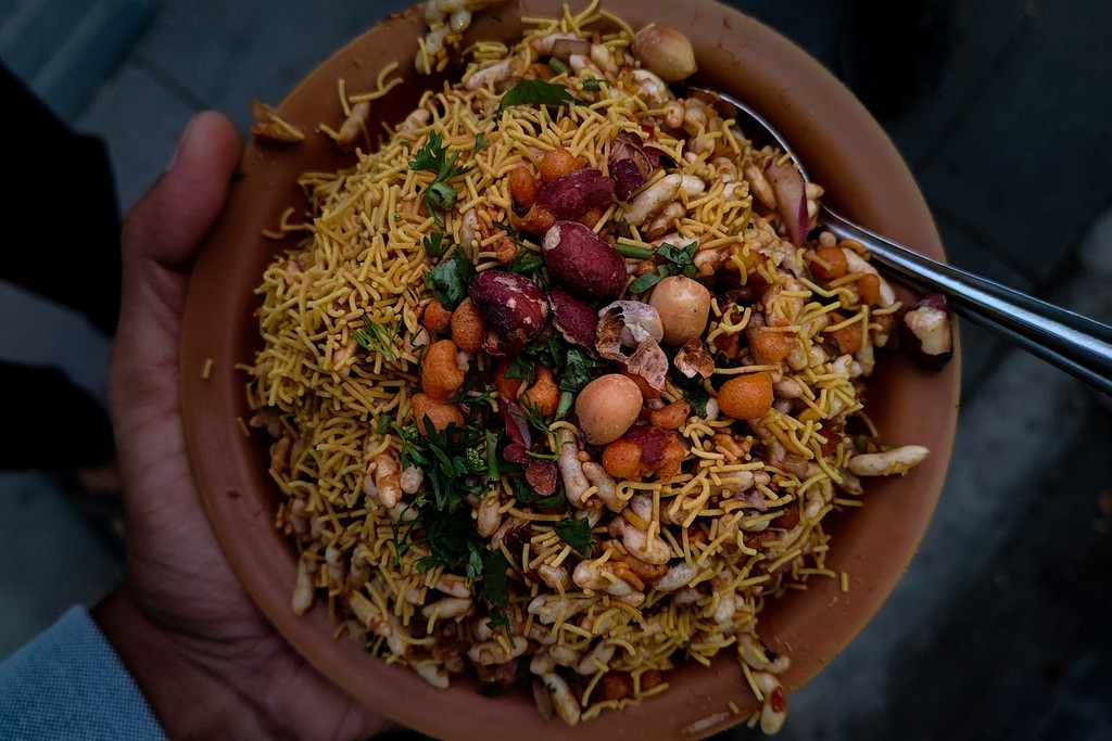 Holding Indian street food bhelpuri chaat dish